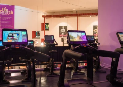 ardiobereich auf der Empore bei The Church Sports & More Rheine mit modernen Life Fitness Laufbändern und Ergometern samt Bildschirmen.